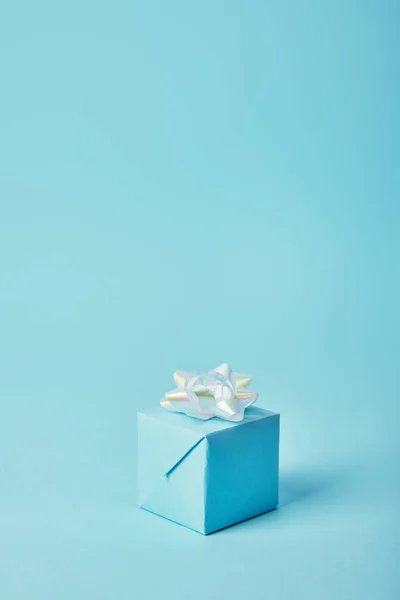 Gift box with white bow on blue background — Stock Photo