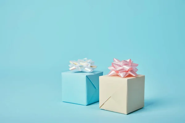 Gift boxes with white and pink bows on blue background — Stock Photo