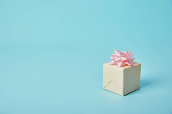Подарункова коробка з рожевим бантом на синьому фоні — стокове фото