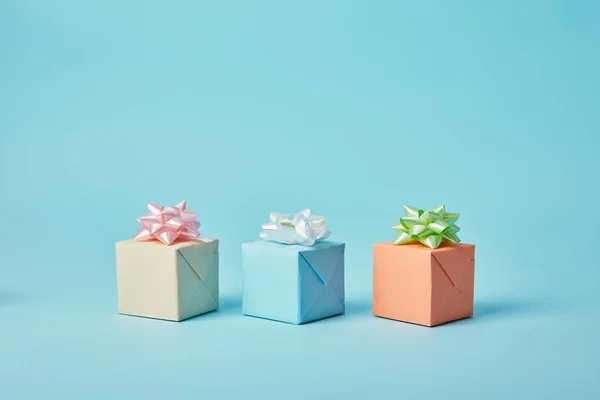 Verschiedene Geschenke mit Schleifen auf blauem Hintergrund — Stockfoto