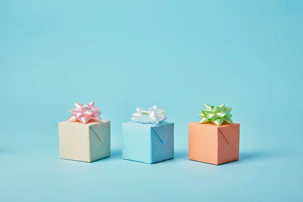 Diferentes regalos con arcos sobre fondo azul - foto de stock