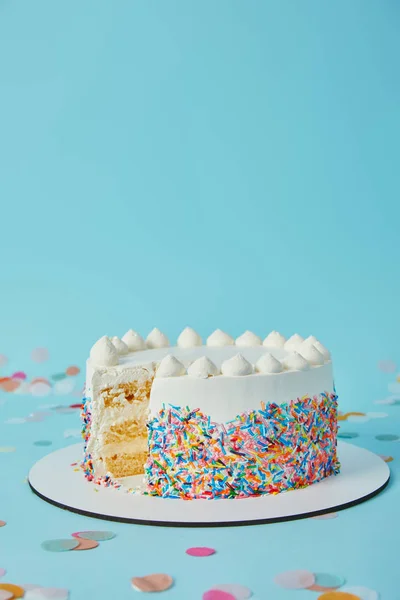 Delicious cake cut into pieces on blue background — Stock Photo