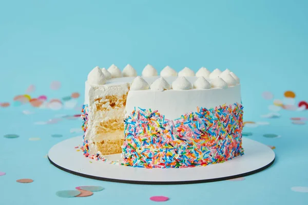 Delizioso taglio torta tagliato su sfondo blu — Foto stock
