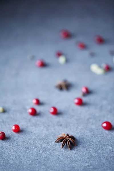 Scattered cranberries and carnation on table in kitchen — Stock Photo
