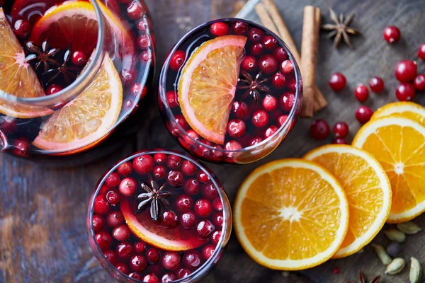 Top view of homemade mulled wine with cranberries and oranges on table in kitchen — Stock Photo