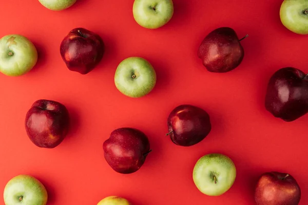 Vue de dessus de délicieuses grandes pommes multicolores sur fond rouge — Photo de stock