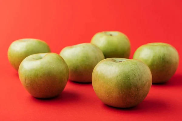 Manzanas verdes maduras grandes sobre fondo rojo - foto de stock