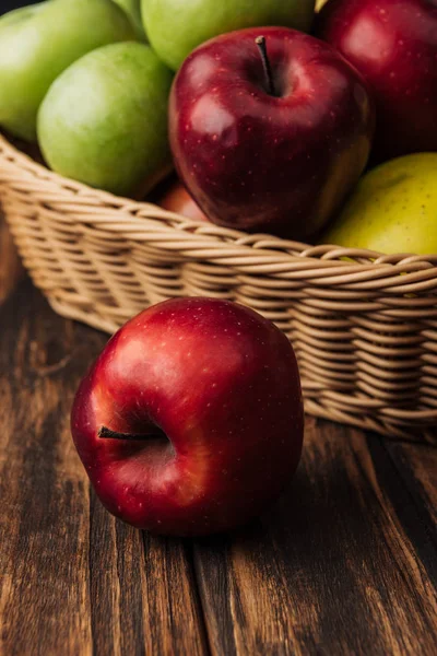 Maçã deliciosa vermelha com cesta de vime de frutas no fundo — Fotografia de Stock