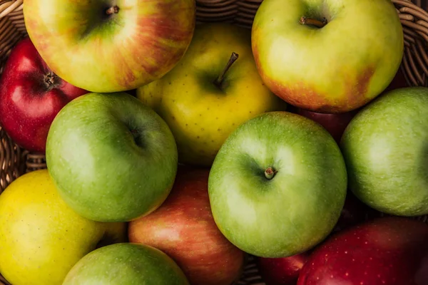 Vista de perto de maçãs maduras multicoloridas em cesta de vime — Fotografia de Stock