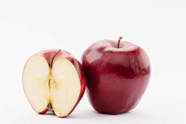 Medio y entero maduro rojo deliciosas manzanas sobre fondo blanco - foto de stock