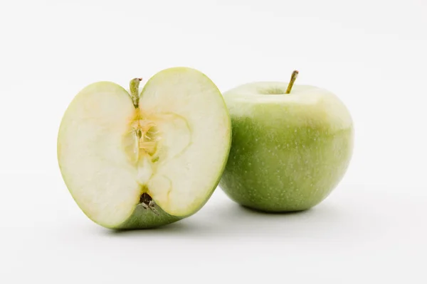 Geschnittene und ganze reife grüne Äpfel auf weißem Hintergrund — Stockfoto