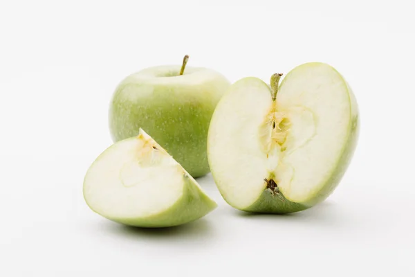 Pommes vertes coupées et entières sur fond blanc — Photo de stock