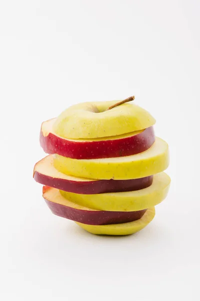 Manzanas rojas y doradas frescas en rodajas sobre fondo blanco - foto de stock