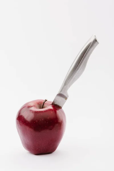 Schnitzmesser in ganz roten köstlichen Apfel isoliert auf weiß — Stockfoto