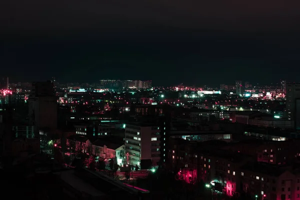 Dunkles Stadtbild bei Nacht mit Gebäuden und bunten Lichtern — Stockfoto