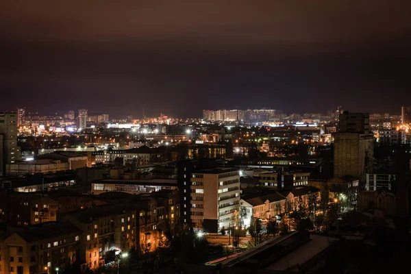 Paisaje urbano con edificios iluminados y calles por la noche - foto de stock