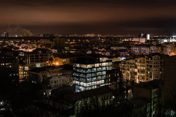 Міський пейзаж з яскравим освітленням у вікнах будівель — стокове фото