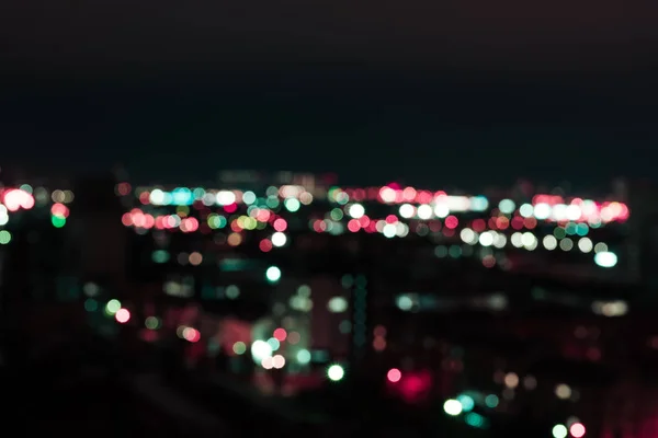Defokussierter dunkler Hintergrund mit hellen Bokeh-Lichtern in der Nacht — Stockfoto