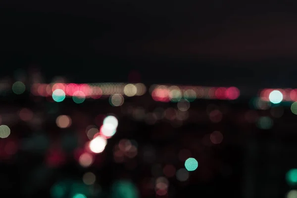 Blurred background at night with colorful bokeh lights — Stock Photo