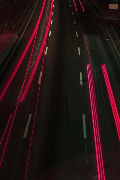 Longue exposition des feux rouges et routiers la nuit — Photo de stock