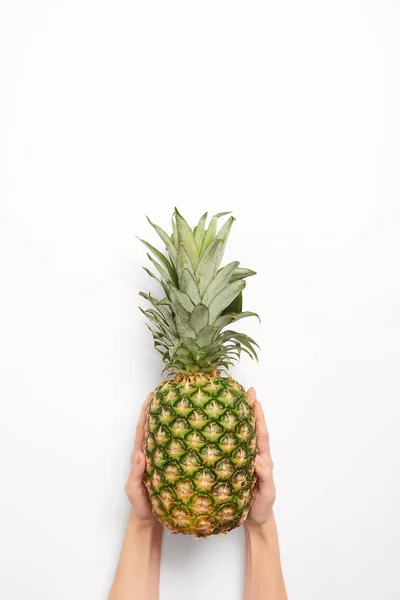Cropped view of woman holding pineapple in hands isolated on white — Stock Photo