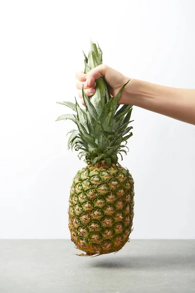 Abgeschnittene Ansicht der weiblichen Hand, die süße Ananas isoliert auf weiß hält — Stockfoto