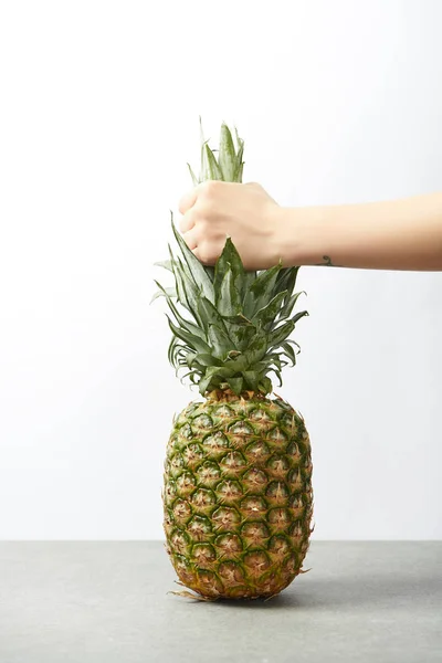 Vue recadrée de la main femelle tenant savoureux ananas isolé sur blanc — Photo de stock