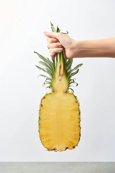 Vue recadrée de la femme tenant l'ananas jaune à moitié à la main isolé sur blanc — Photo de stock