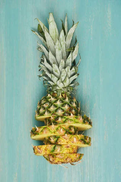 Vue du dessus de l'ananas jaune tranché sur table en bois turquoise — Photo de stock