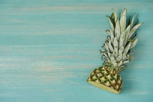 Top view of cut ripe pineapple on turquoise wooden table — Stock Photo