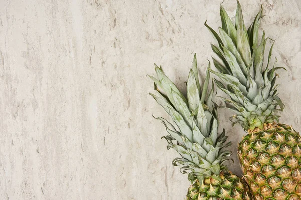 Vue de dessus des ananas bio et savoureux sur fond de marbre — Photo de stock
