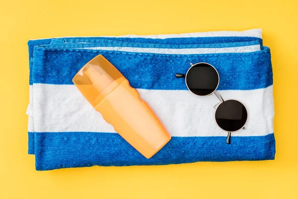 Top view of towel and sunglasses isolated on yellow — Stock Photo