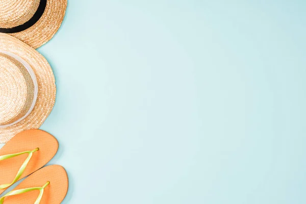 Top view of straw hats and flip flops on blue background — Stock Photo