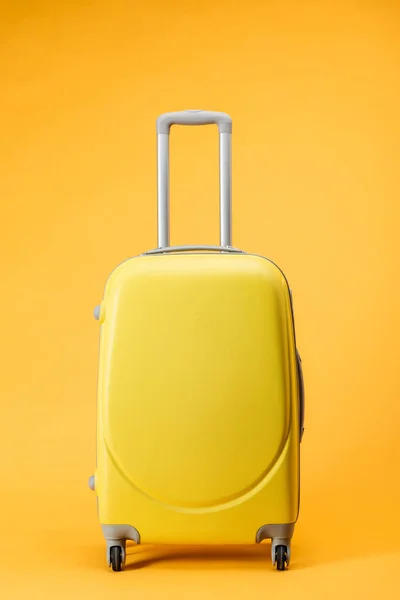 Sac de voyage avec roues et poignée sur fond jaune — Photo de stock