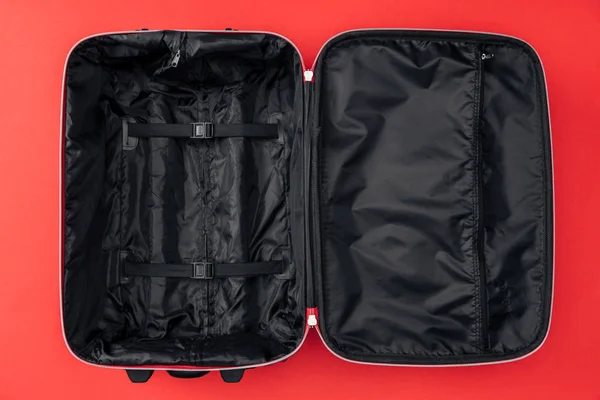 Vista superior de la bolsa de viaje vacía aislada en rojo - foto de stock