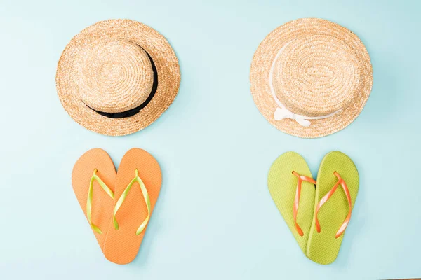Top view of straw hats and flip flops on blue background — Stock Photo
