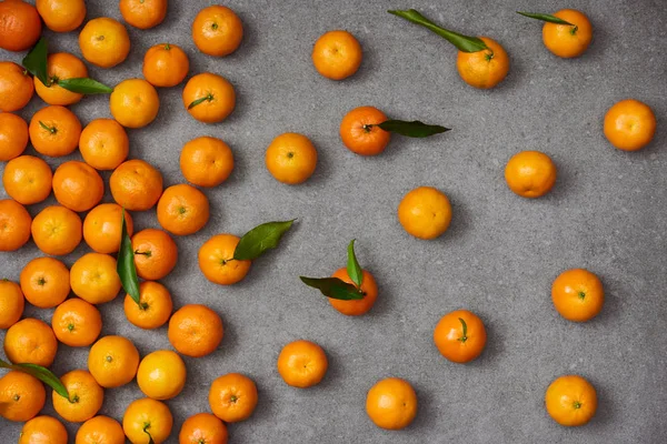 Vista superior de tangerinas laranja doce com folhas verdes na mesa cinza — Fotografia de Stock