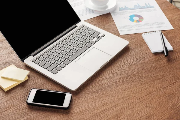 Foto de laptop e smartphone com tela em branco na superfície de madeira — Fotografia de Stock