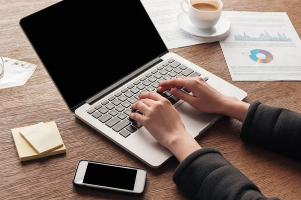 Ausgeschnittene Ansicht einer Frau, die am Arbeitsplatz auf der Laptop-Tastatur tippt — Stockfoto