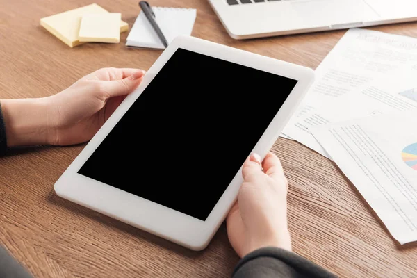Vista recortada de la mujer usando tableta digital con pantalla en blanco en el lugar de trabajo - foto de stock