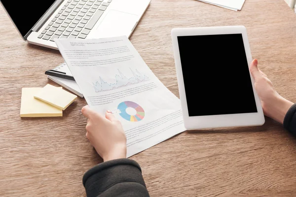 Vista recortada de la mujer sosteniendo documentos y tableta digital con pantalla en blanco - foto de stock