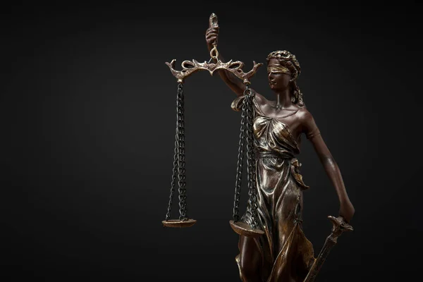 Statuette en bronze avec écailles de justice isolées sur noir — Photo de stock