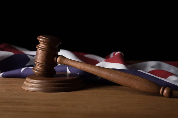 Wooden gavel and american flag on table isolated on black — Stock Photo