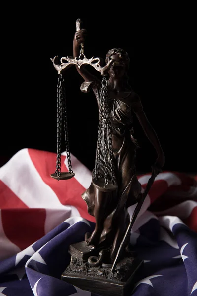 Estatuilla de bronce con escamas de justicia y bandera americana aislada en negro - foto de stock