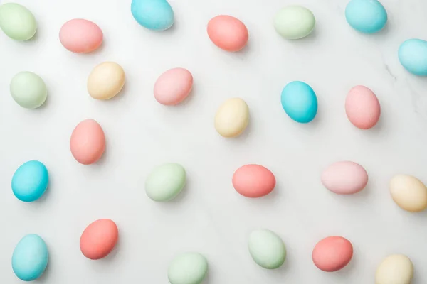 Fond avec des œufs de Pâques pastel colorés sur blanc — Photo de stock