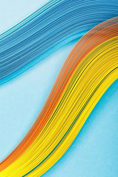 Top view of yellow, orange and blue abstract lines on blue background — Stock Photo