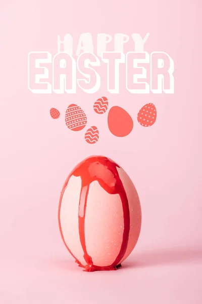 Pink chicken egg with dripping red paint on pink background with happy Easter lettering — Stock Photo