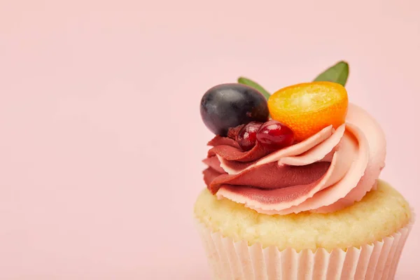 Magdalena dulce con crema y frutas aisladas en rosa - foto de stock