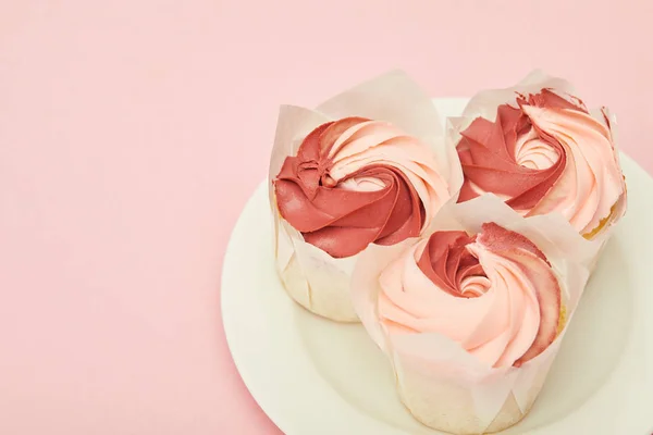 Prato com cupcakes saborosos doces na superfície rosa — Fotografia de Stock