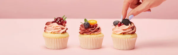 Plano panorámico de la mujer con cupcakes en la superficie rosa - foto de stock